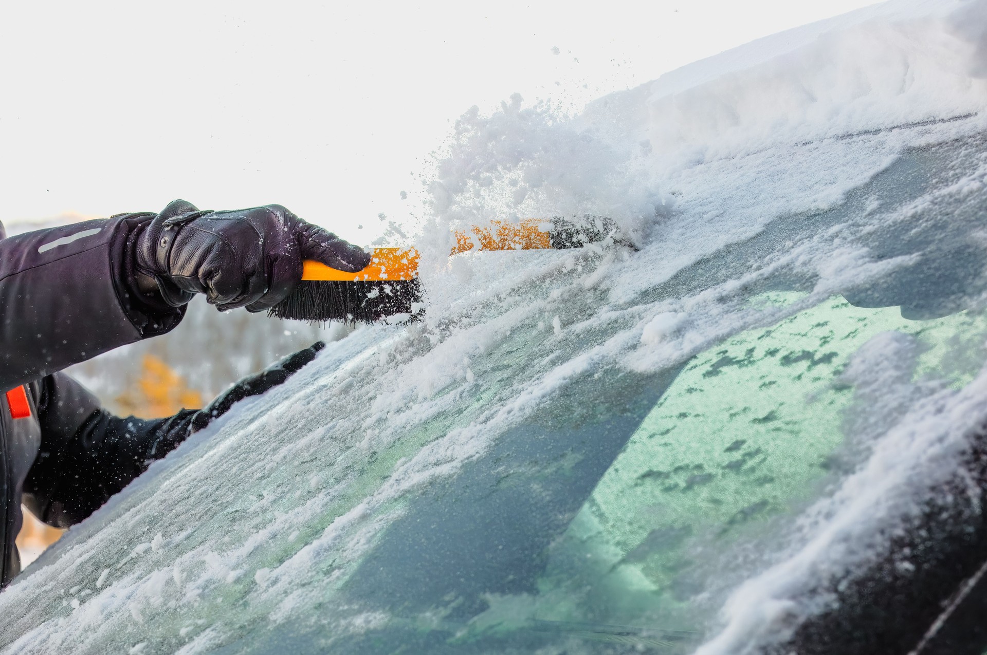 Clearing ice from car windshield.